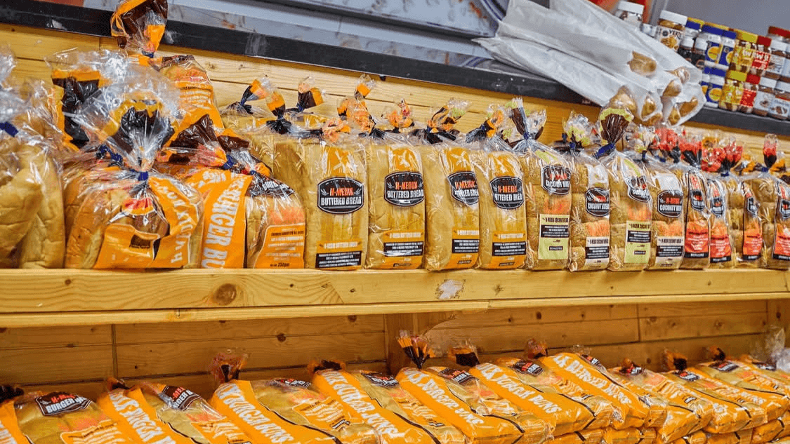 The clean, organized bakery aisle at H-Medix, featuring packaged sliced bread.