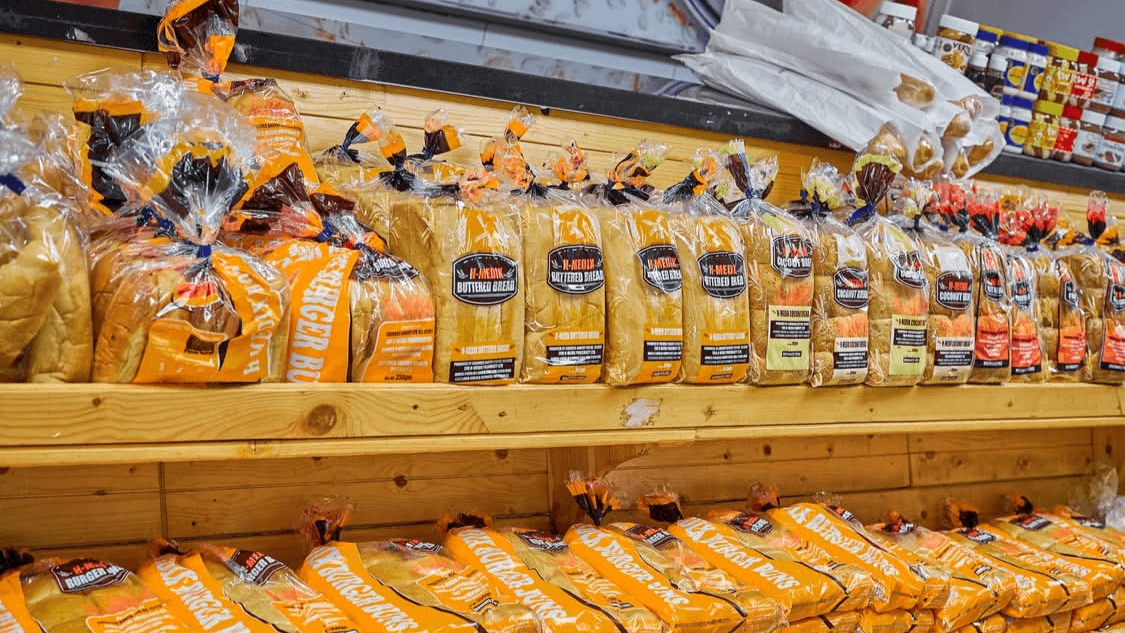 The clean, organized bakery aisle at H-Medix, featuring packaged sliced bread.